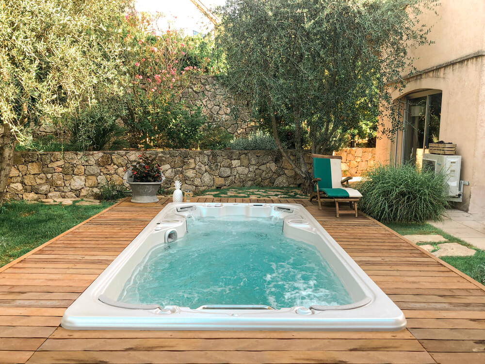 swim spa installed on a wooden deck in a backyard