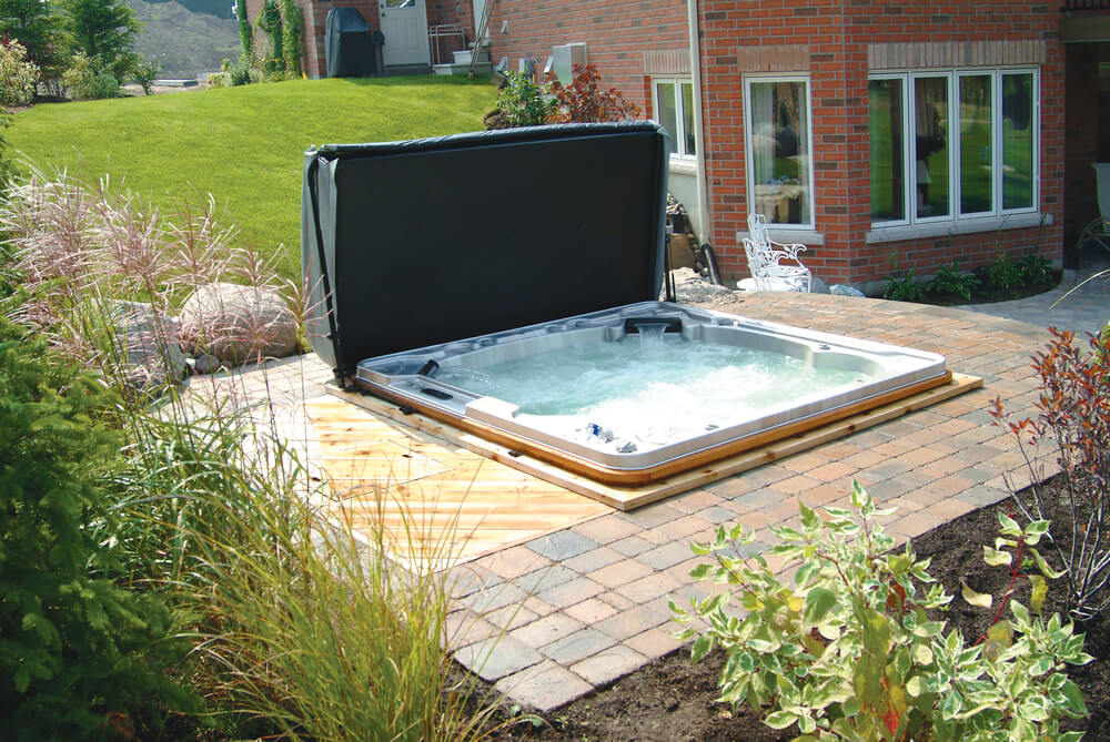 backyard hot tub with a brick patio.