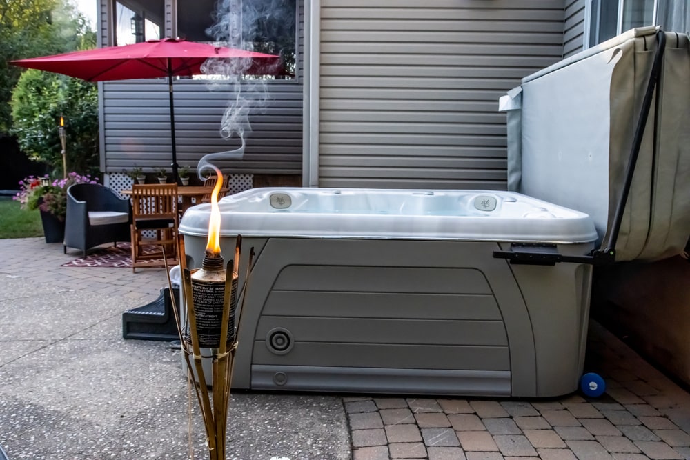 backyard hot tub with a wooden deck and patio furniture