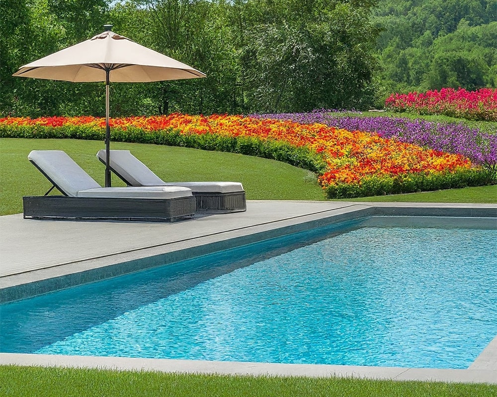 Luxurious swimming pool with crystal clear water, adjacent to a lounge chair under an umbrella